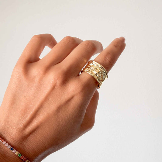 Detalle de textura tipo lava fundida en anillo dorado ancho bisutería fina colombiana baño oro 18k