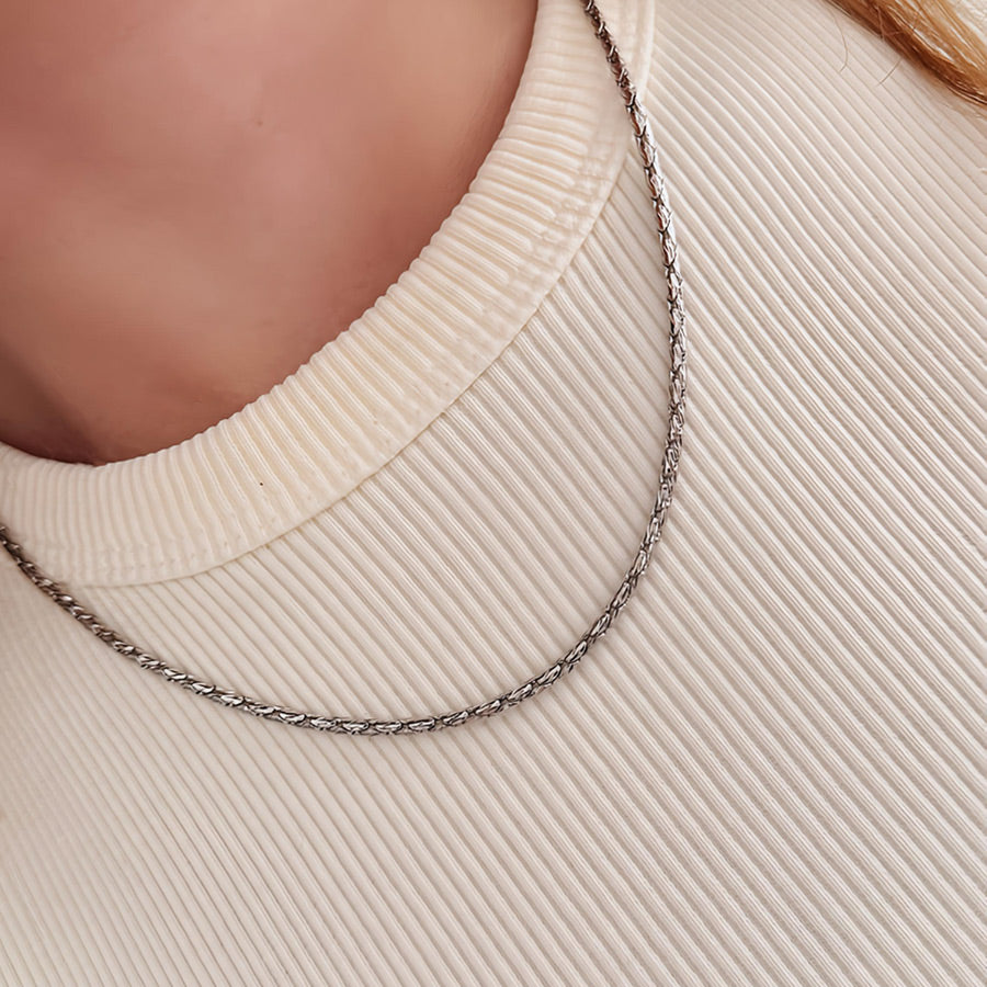 Collar minimalista plateado tejido serpiente con cierre pico de loro.