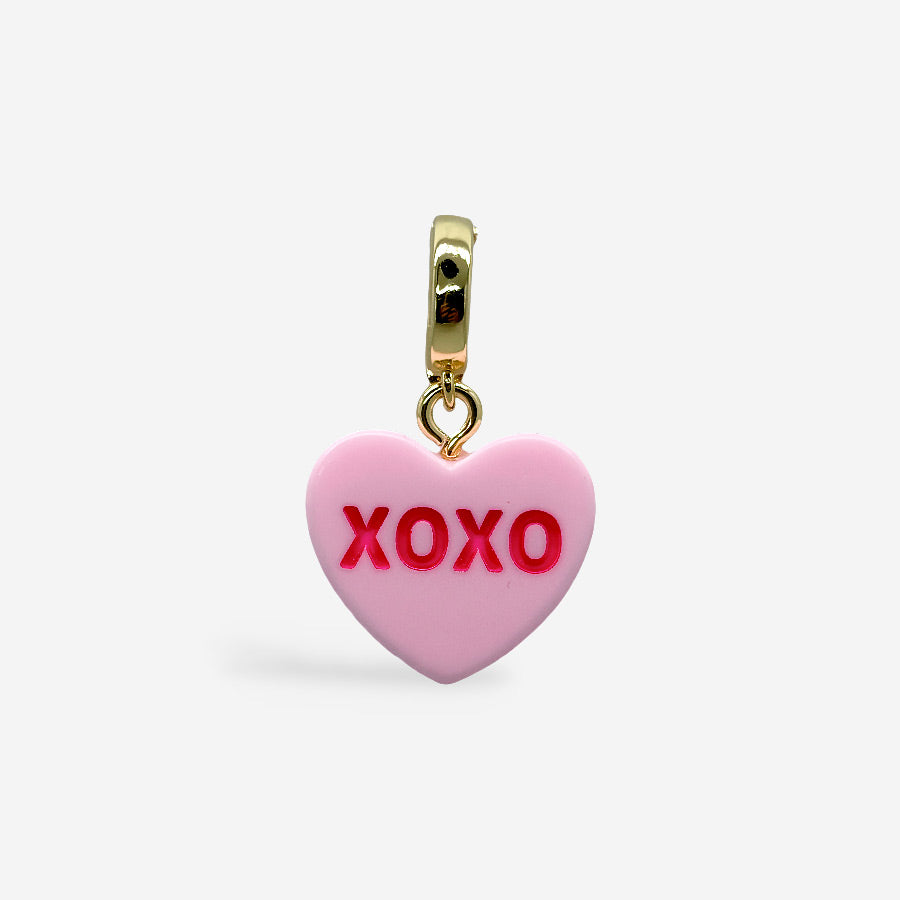 Dije corazón rosa con texto XOXO colgado de broche dorado