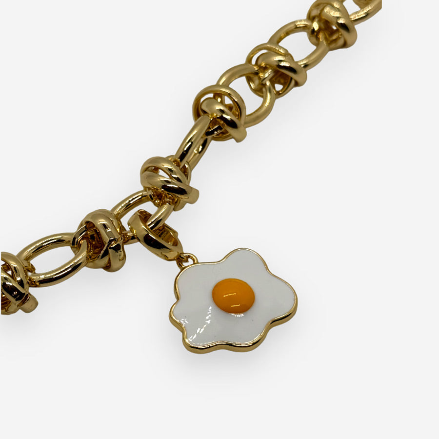 accesorio pop: dije de huevo frito brillante con aro dorado.