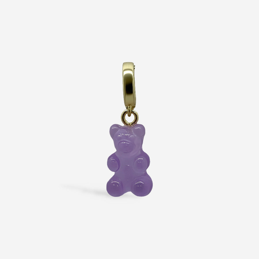 Dije osito de goma morado con broche dorado, sobre fondo blanco.