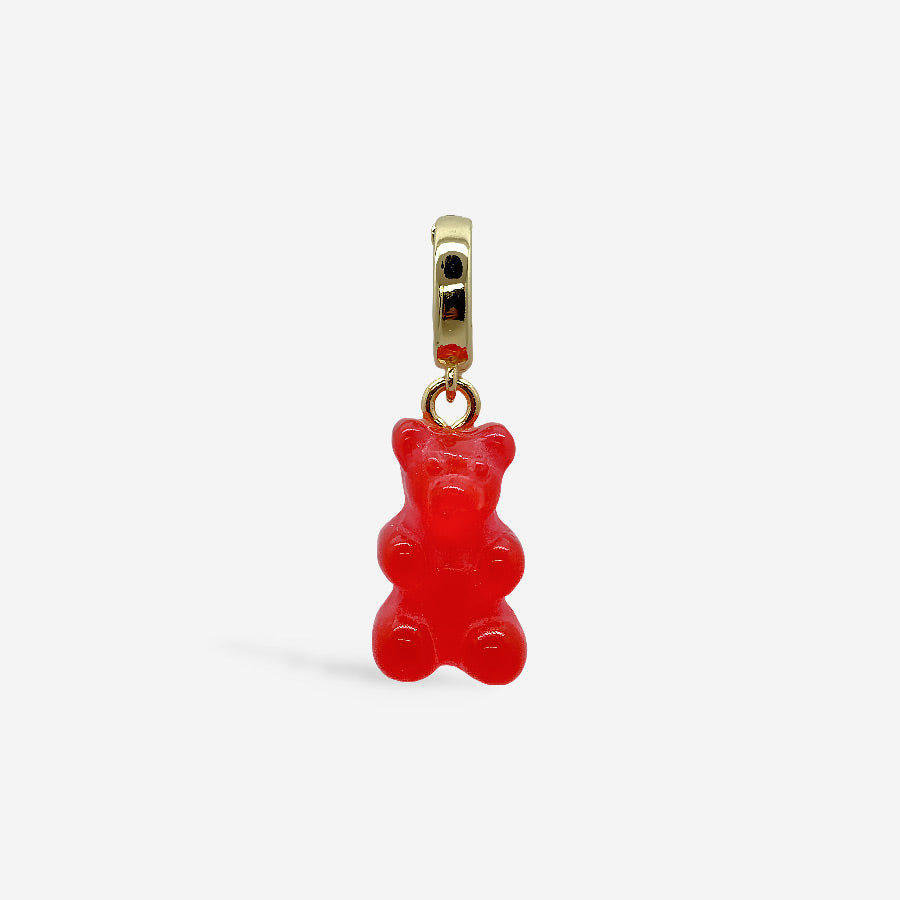 Dije osito de goma rojo con broche dorado, sobre fondo blanco.