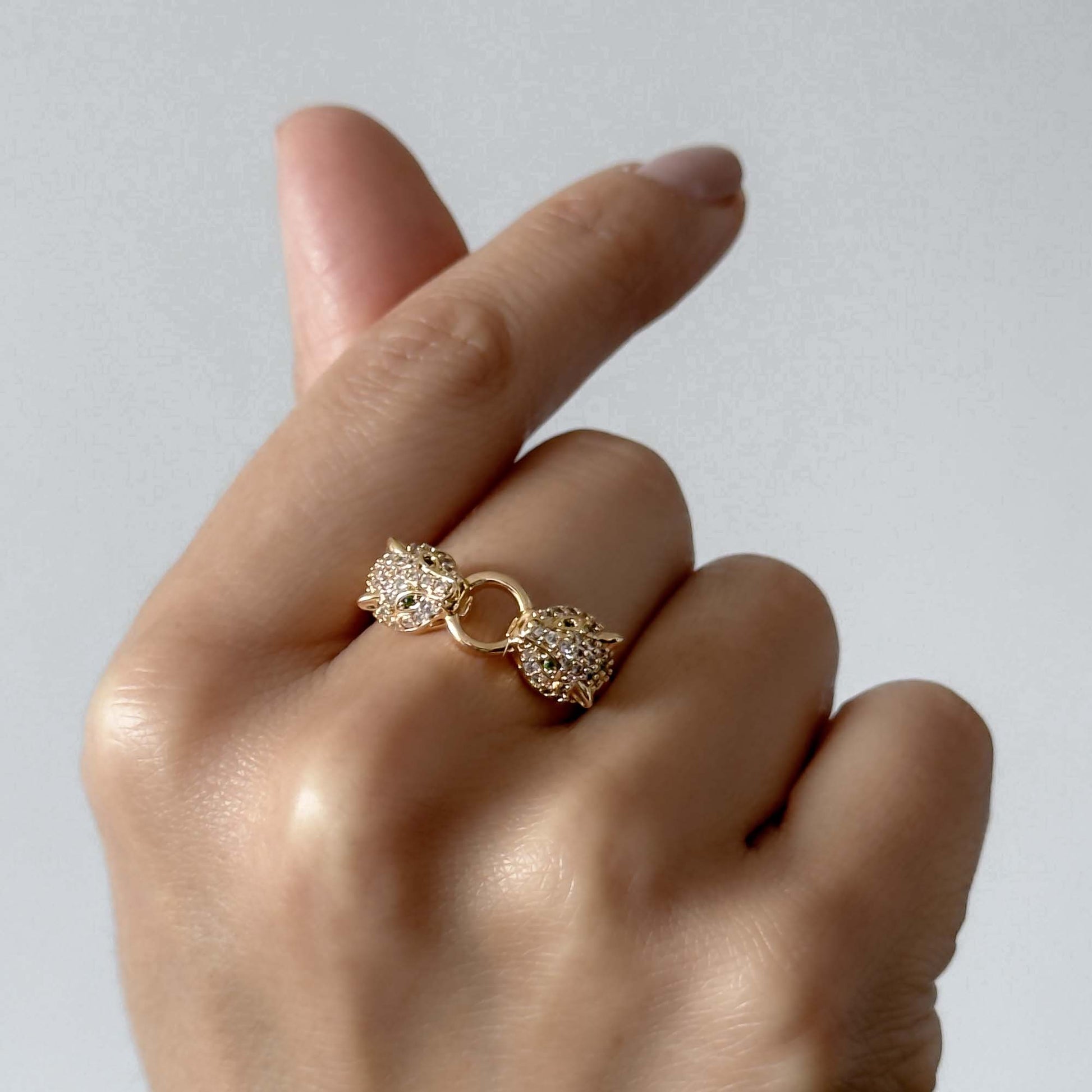 Anillo dorado con doble cabeza de pantera y circonias