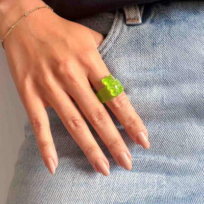 Anillo verde de osito en resina puesto sobre la mano con luz natural