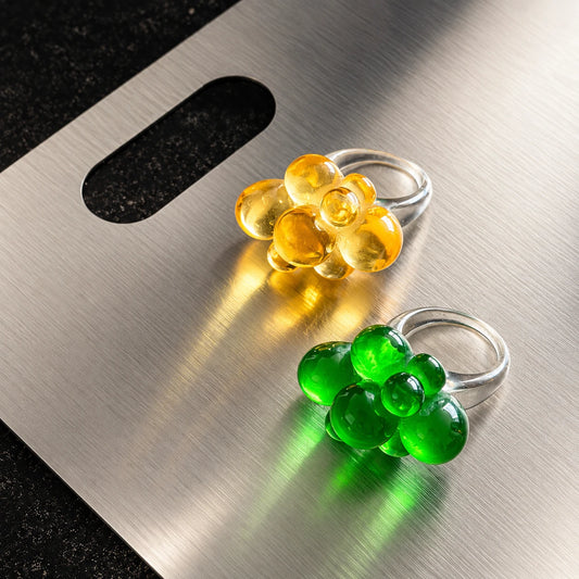 Anillos Bubble Flower de resina en colores verde y amarillo con diseño de flor translúcida
