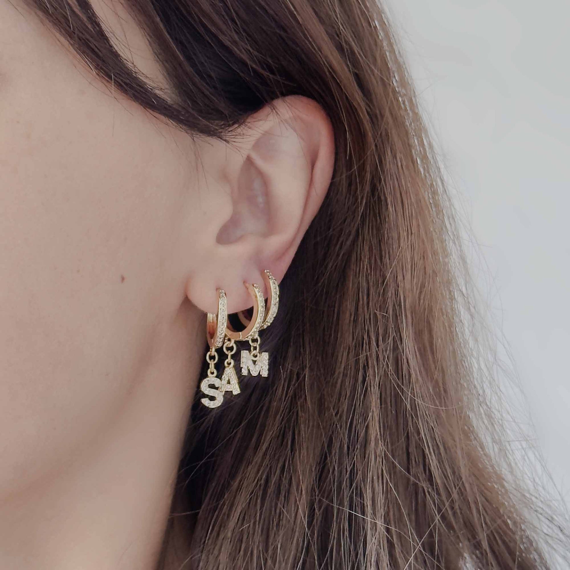 Arete tipo candonga con letra dorada para mujer