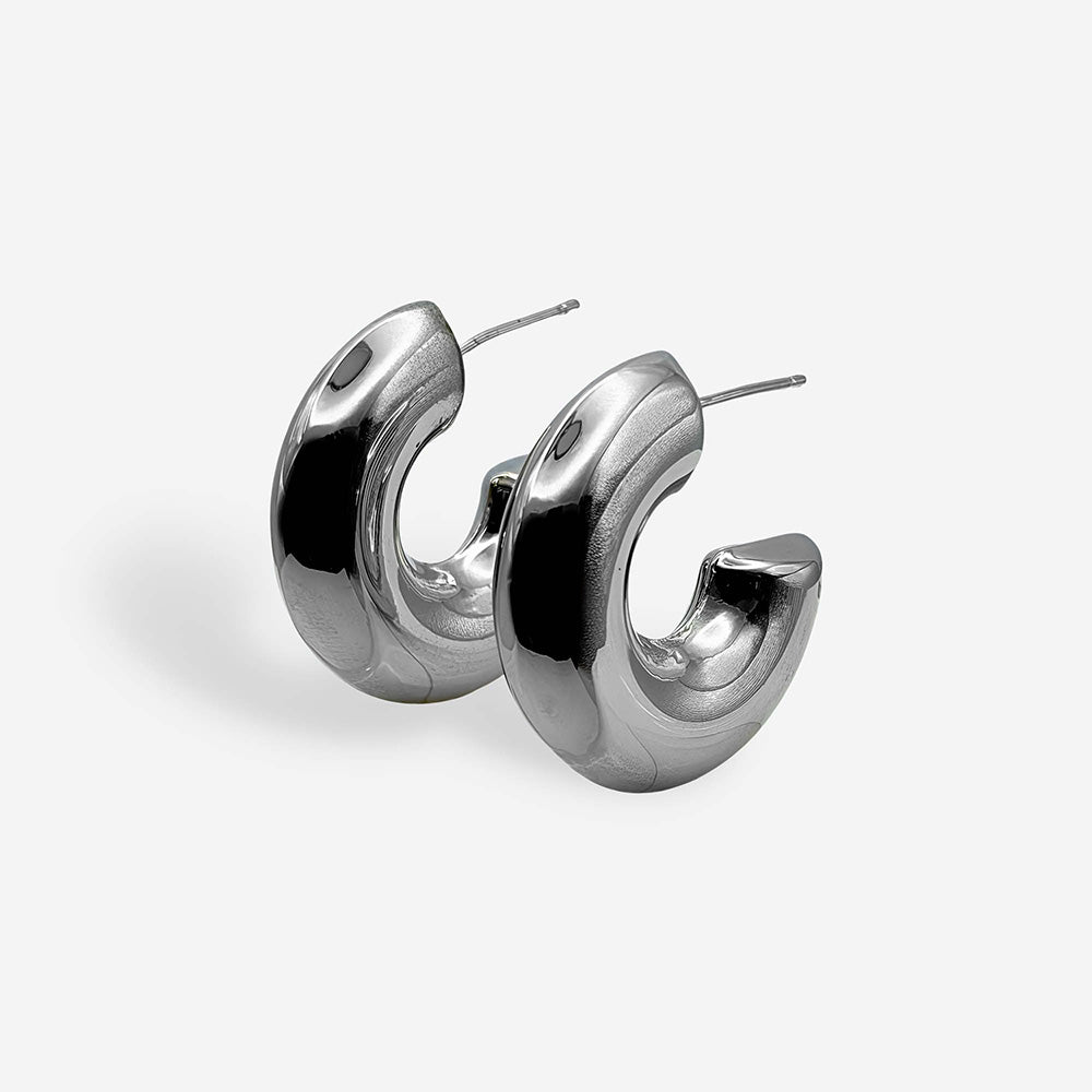 Aretes chunky plateados para mujer elaborados en cobre con baño de rodio y diseño voluminoso.