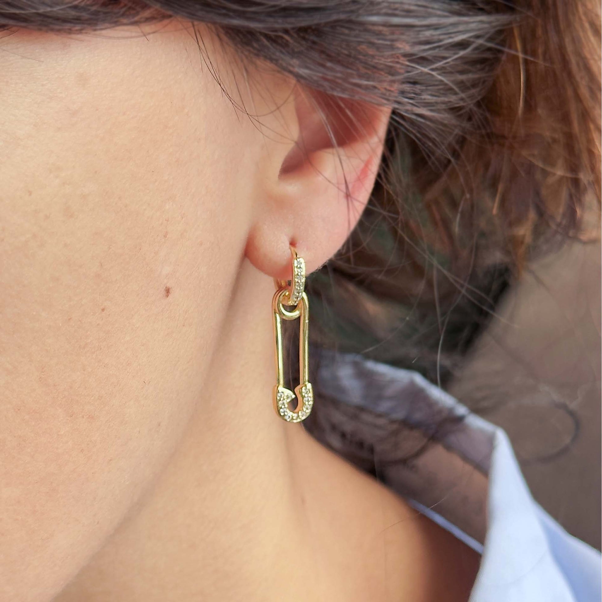 Aretes dorados con zirconias en look moderno y minimalista