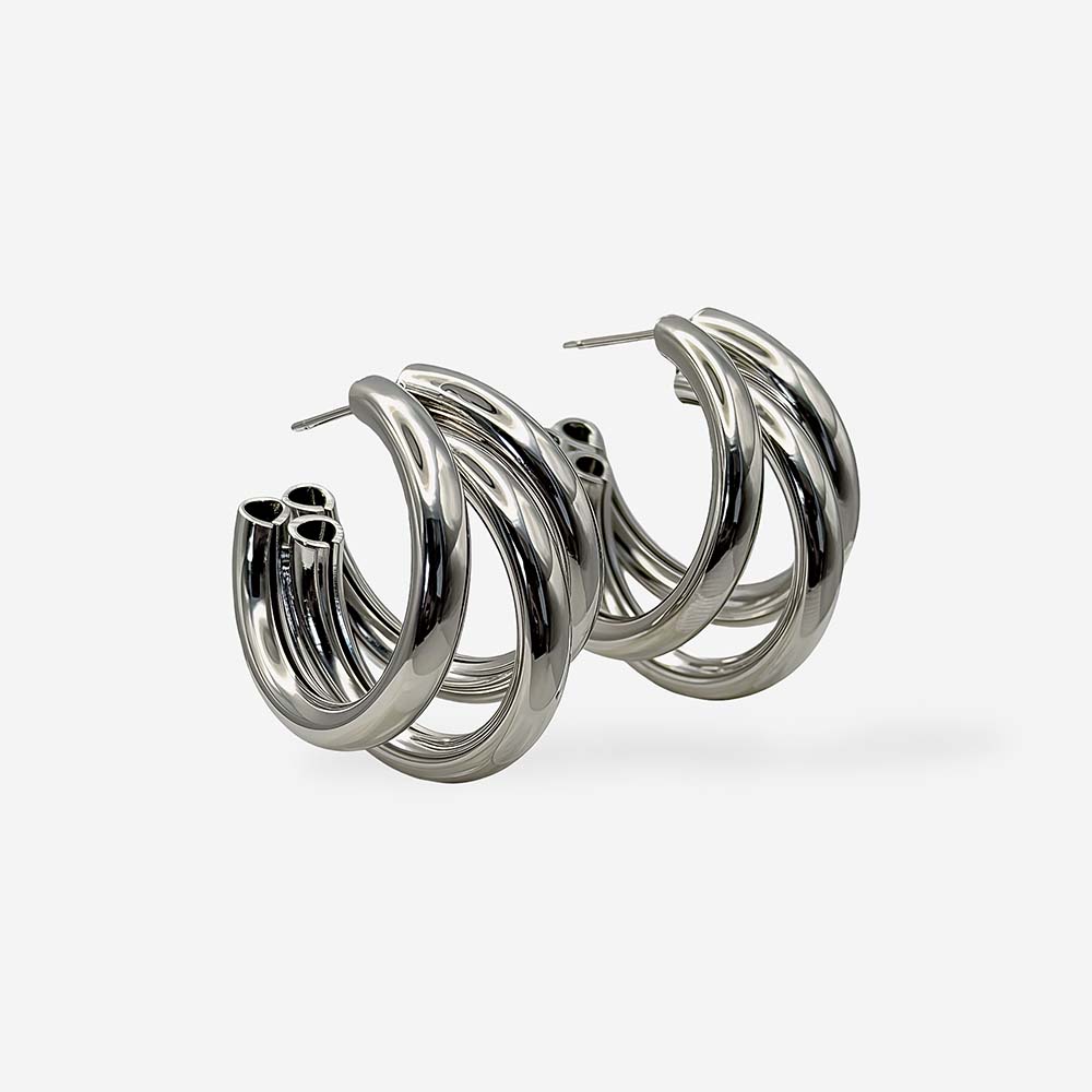 Aretes maxi plateados para mujer con diseño de triple aro y baño de rodio hipoalergénico.
