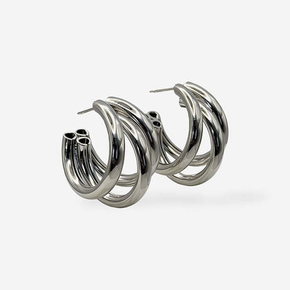 Aretes maxi plateados para mujer con diseño de triple aro y baño de rodio hipoalergénico.