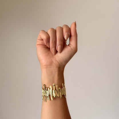Brazalete Melted dorado con estructura calada tipo metal derretido, baño oro 18k, 19/86 Studio Colombia