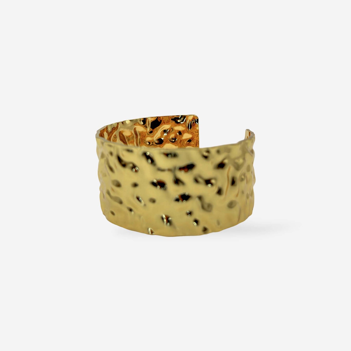 Brazalete cuff abierto con acabado martillado en oro 18k, 3 cm de ancho, sobre fondo blanco