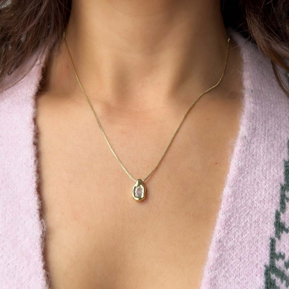Collar ajustable con cadena tipo veneciana y dije orgánico utilizado en layering con otros collares delicados.