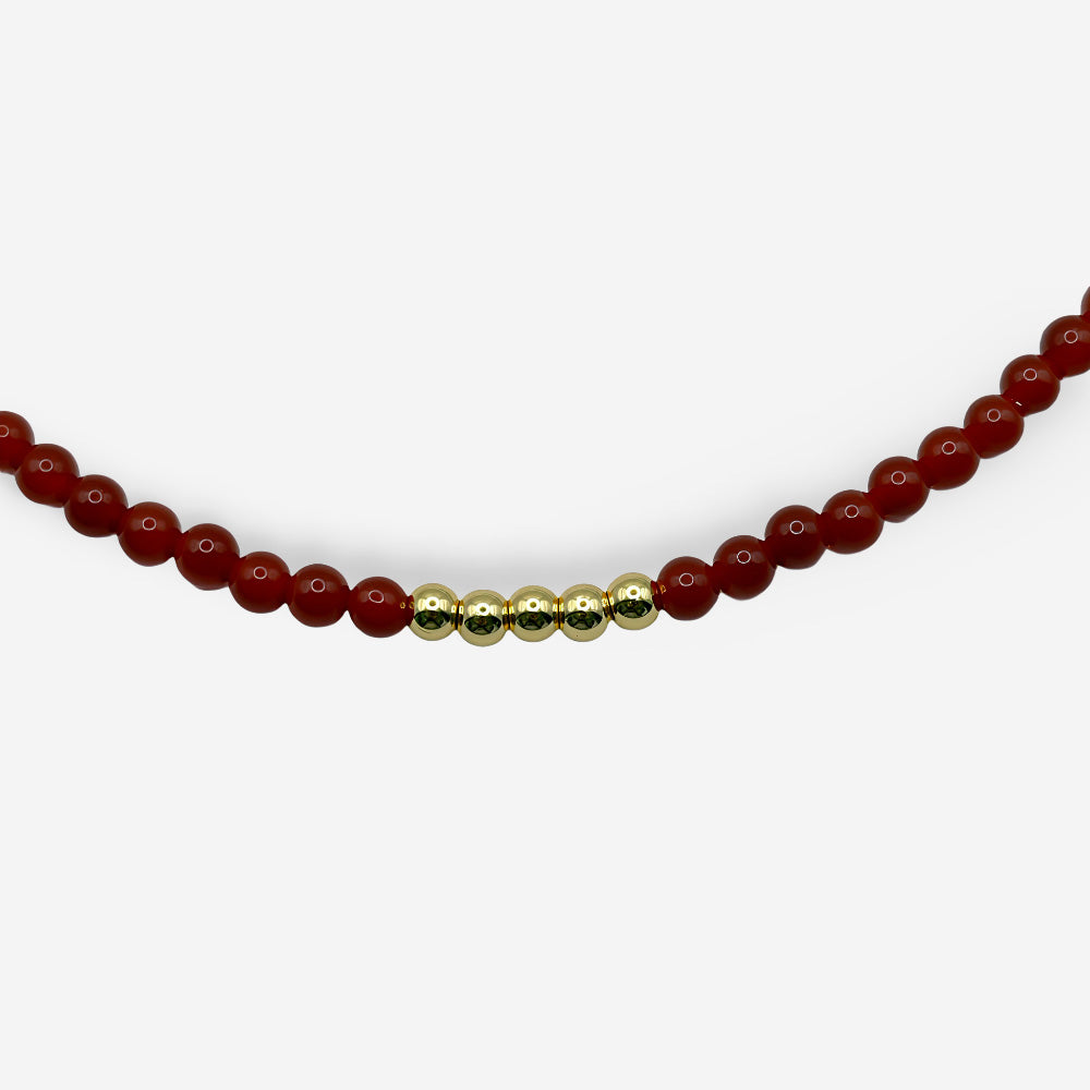 Collar ajustable con piedra natural cornalina roja, esferas doradas y diseño mixto de cuentas y eslabones.