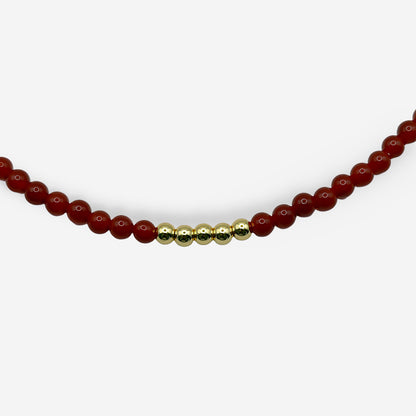 Collar ajustable con piedra natural cornalina roja, esferas doradas y diseño mixto de cuentas y eslabones.
