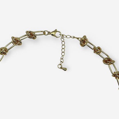 Collar ajustable de cadena dorada con eslabones decorados con nudos y cierre tipo langosta.