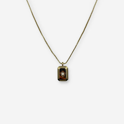 Collar dorado ajustable elaborado en cobre con baño de oro de 18K y dije rectangular con circonia central.