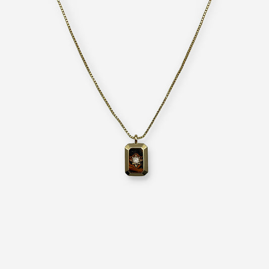 Collar dorado ajustable elaborado en cobre con baño de oro de 18K y dije rectangular con circonia central.