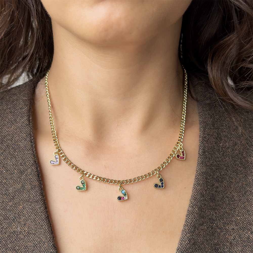 Collar dorado con dijes de corazón utilizado en layering para aportar un toque divertido y sofisticado