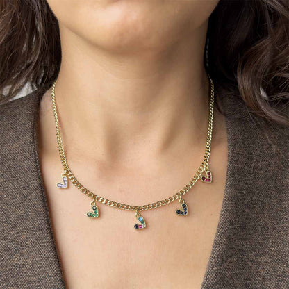 Collar dorado con dijes de corazón utilizado en layering para aportar un toque divertido y sofisticado
