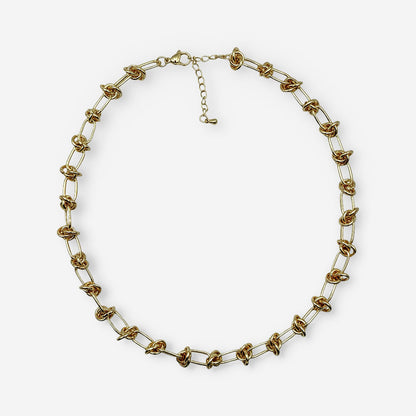 Collar dorado para mujer elaborado en bronce con baño de oro de 18K y diseño de eslabones ovalados con detalles de nudo.