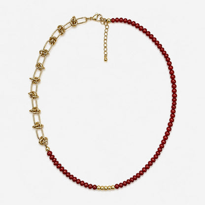 Collar para mujer elaborado en bronce con baño de oro de 18K, cuentas de cornalina roja natural y cadena dorada con detalles de nudo.