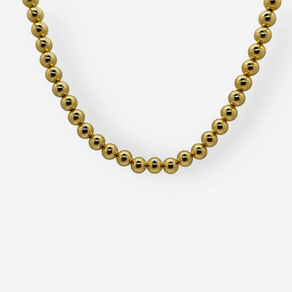 Detalle collar dorado con balines brillantes