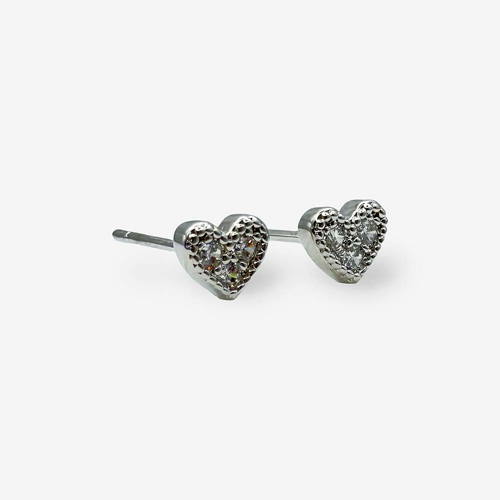Detalle de aretes tipo topo en forma de corazón con baño de rodio, ideales para el uso diario.