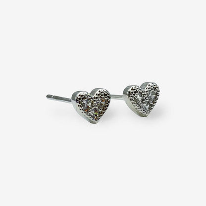 Detalle de aretes tipo topo en forma de corazón con baño de rodio, ideales para el uso diario.