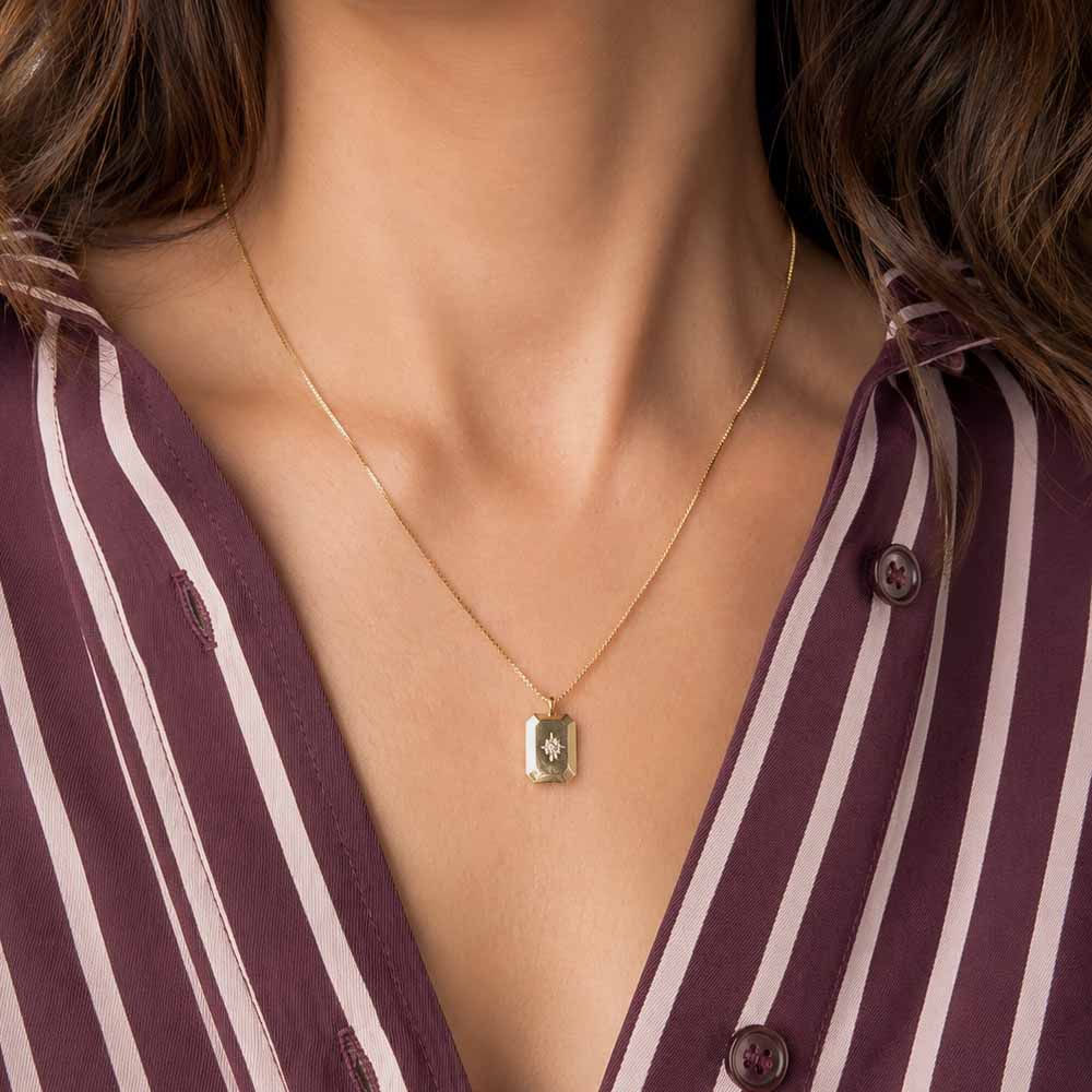 Detalle de collar ajustable con colgante geométrico dorado complementando un look elegante y minimalista.