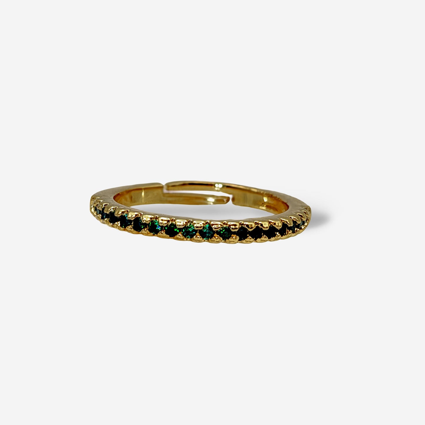 Detalle de piedras circonia verde esmeralda sobre banda delgada dorada ajustable baño oro 18k
