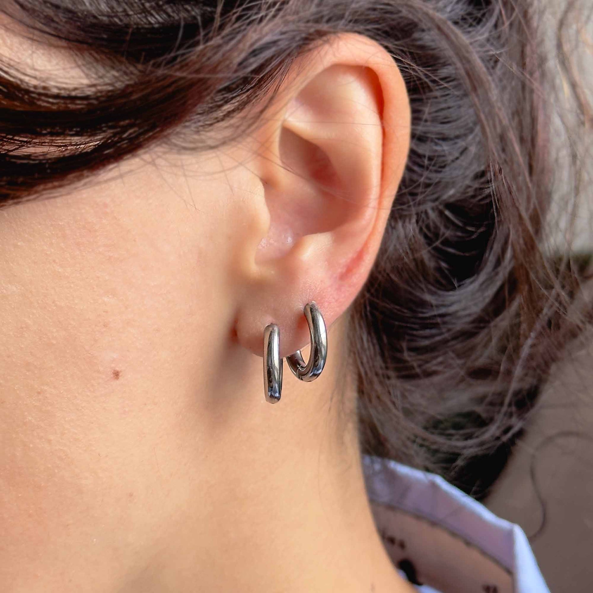 Mini hoops plateados puestos en look casual y moderno