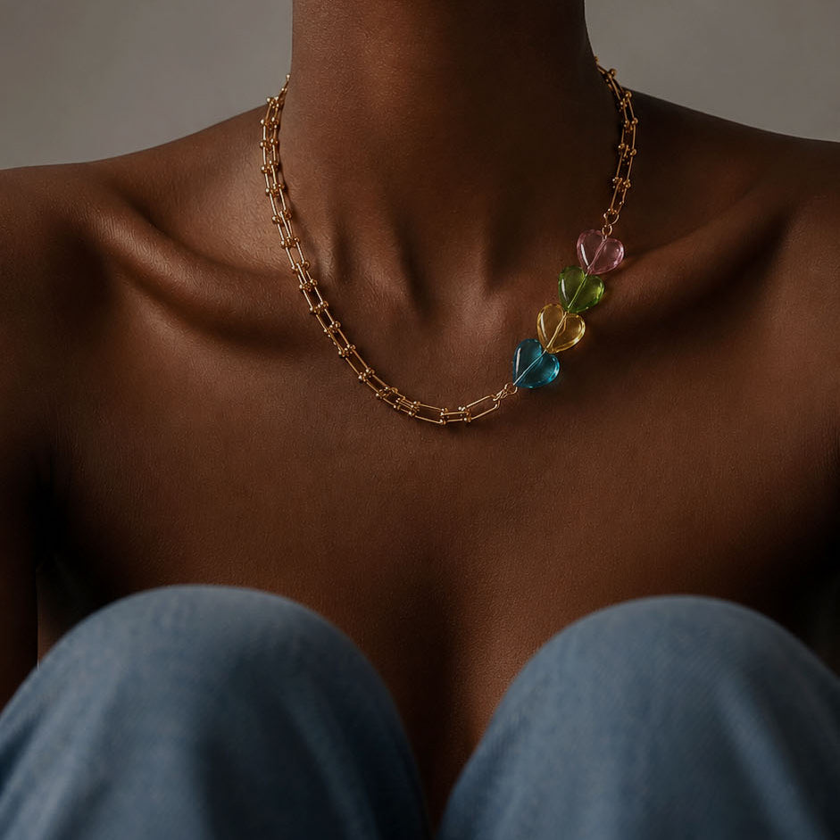 Mujer con collar de cadena dorada y dijes de acrílico de colores
