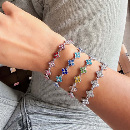 Mujer usando Pulsera Trébol Plateada con circonias de colores.