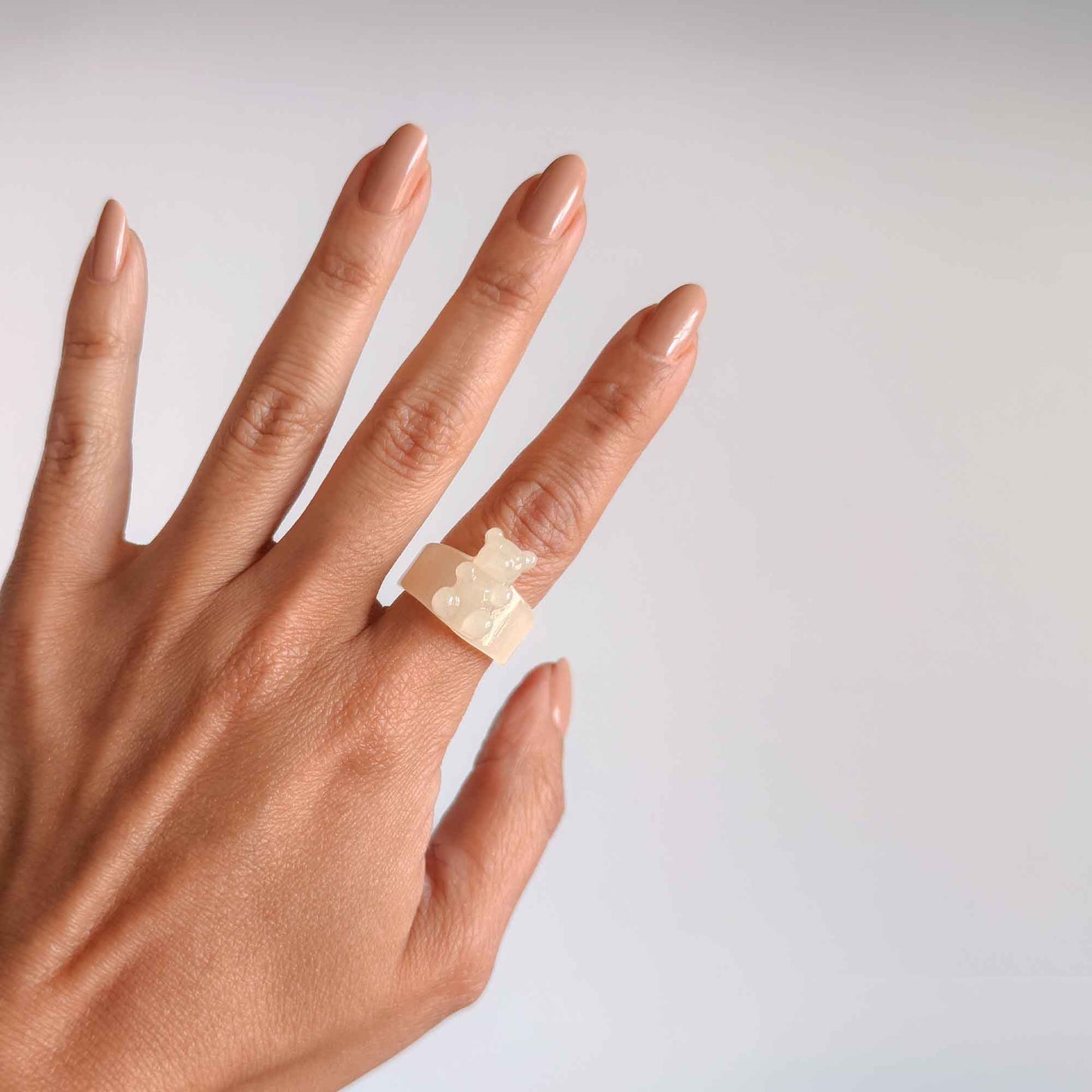Mujer usando anillo blanco de osito en resina transparente