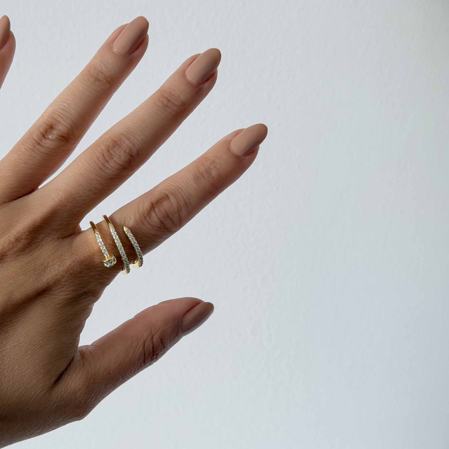 Mujer usando anillo dorado ajustable con diseño de clavo