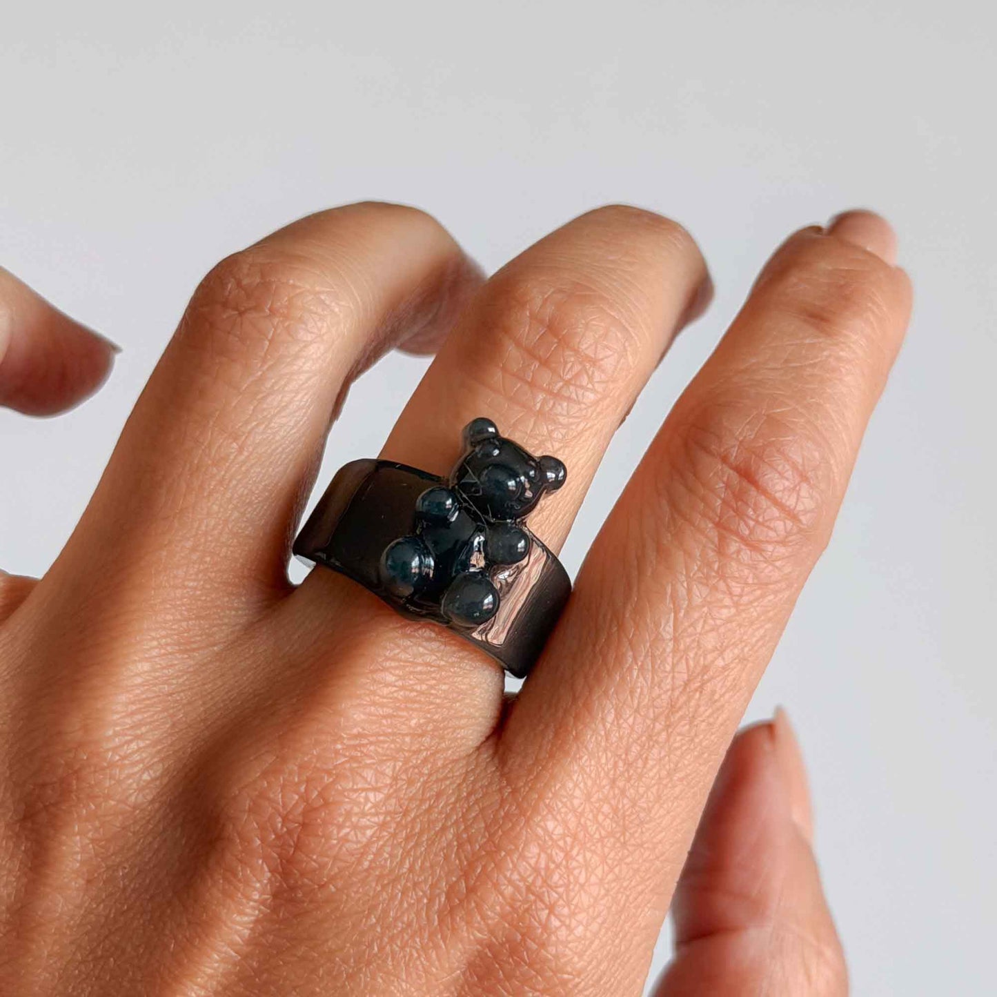 Mujer usando anillo negro de osito en resina transparente