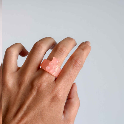 Mujer usando anillo rosa de osito en resina transparente