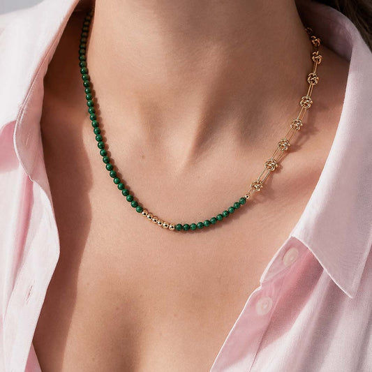 Mujer usando collar con malaquita natural verde y detalles dorados para mostrar su caída y proporción sobre el cuello.