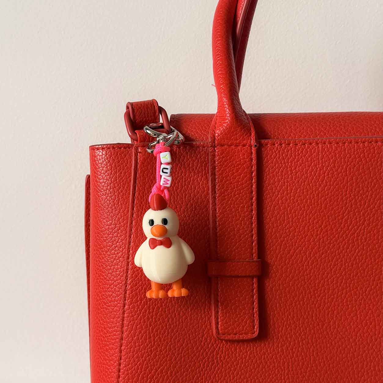 bolso rojo con llavero con dije de pollo, el pollo de la marca de frisby