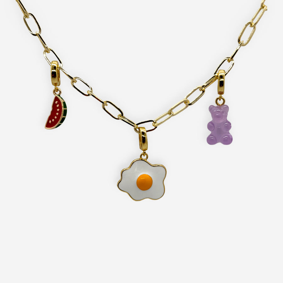 Accesorio tipo dije en forma de sandía con acabado dorado y esmalte rojo