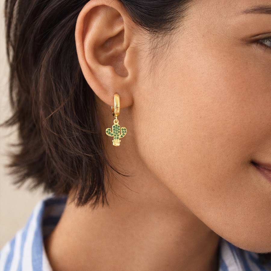 mujer con candongas doradas con dije cactus