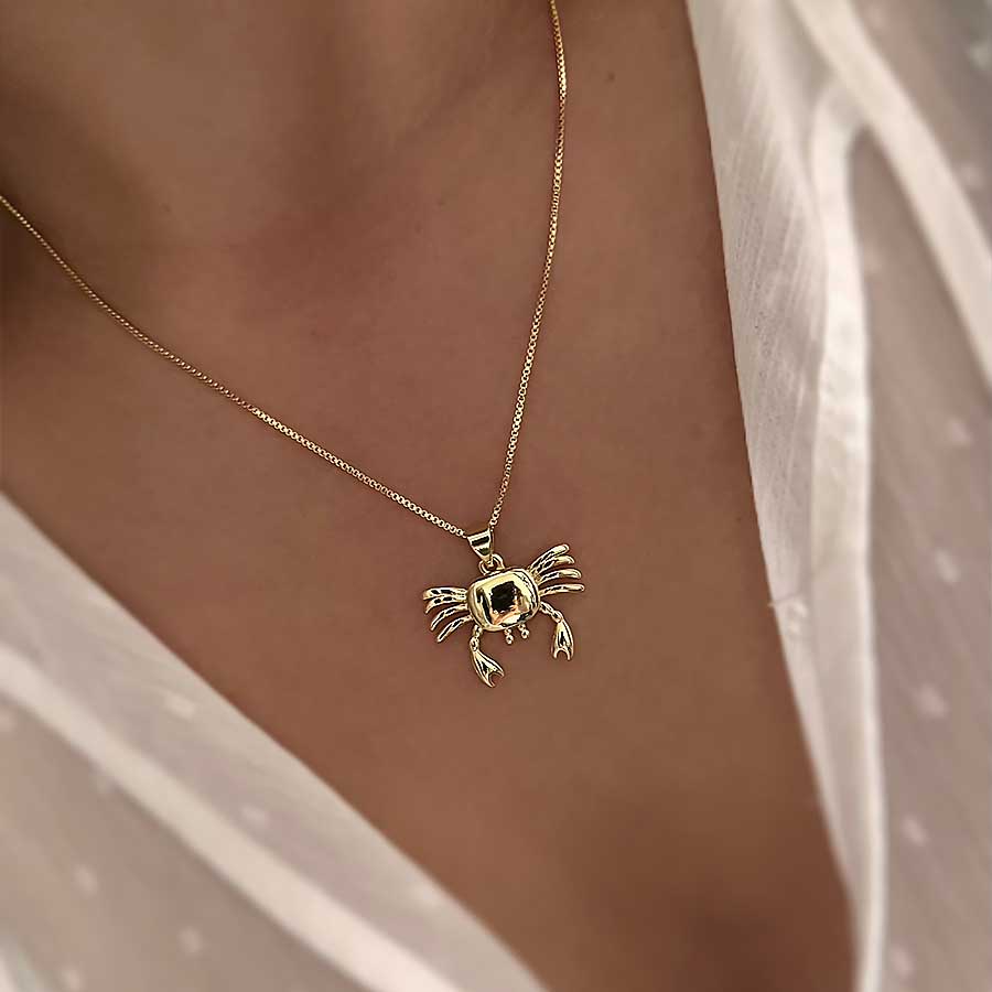 Detalle de collar de cangrejo dorado con acabado brillante