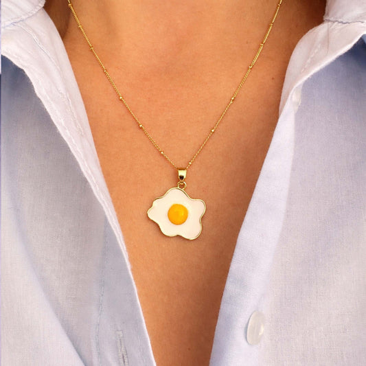 mujer con collar con dije de huevo frito