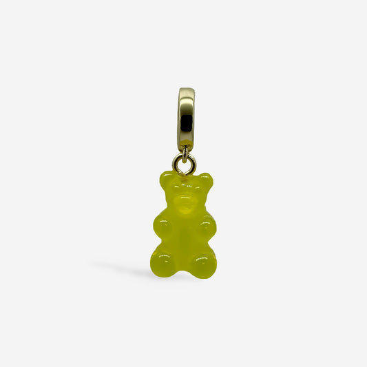 Dije osito de goma amarillo con broche dorado, sobre fondo blanco.