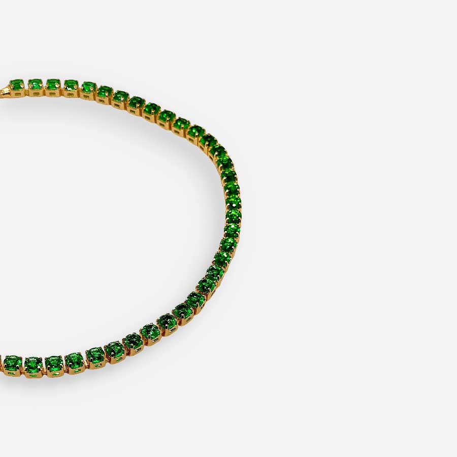 Pulsera dorada con circonias verdes en primer plano