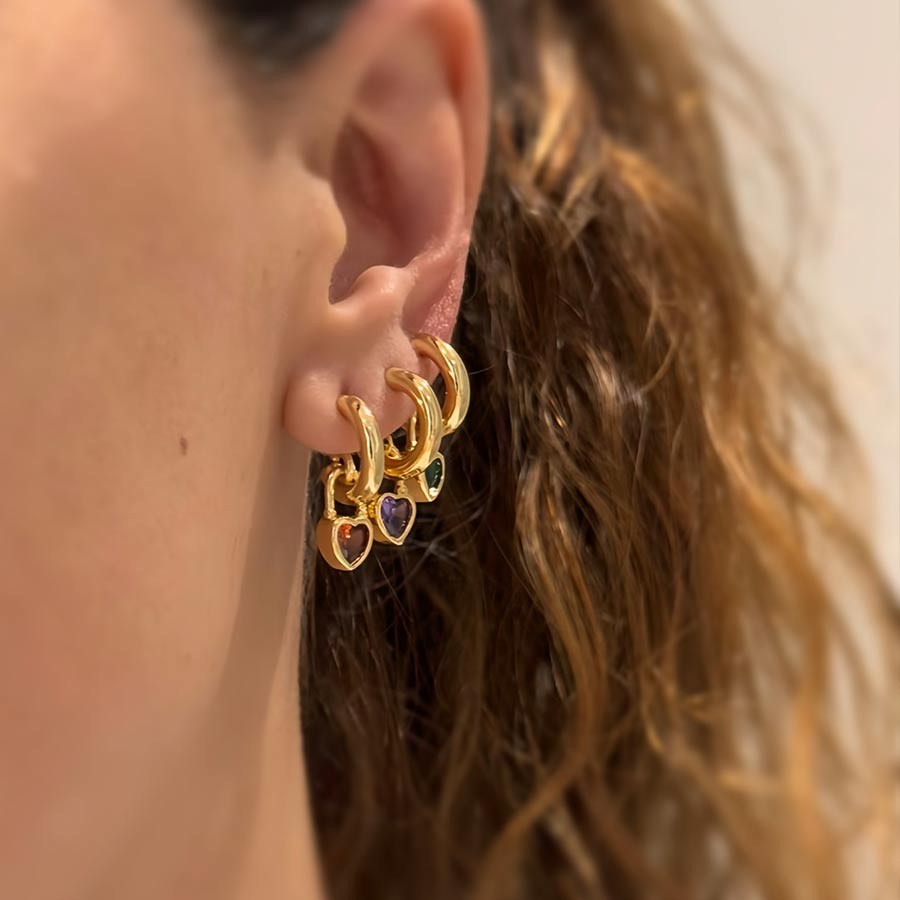 oreja de mujer con candongas doradas con dijes de corazones