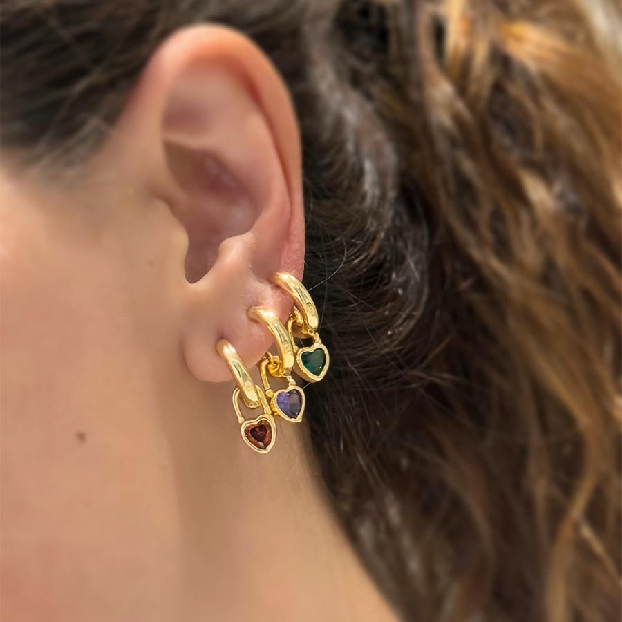 oreja de mujes con candongas doradas con dijes de corazones